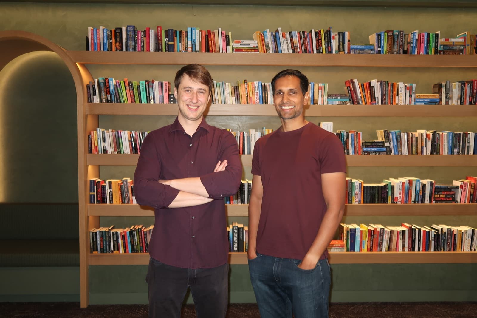 Tyler Lambe and Shalin Mantri in front of a wall of books